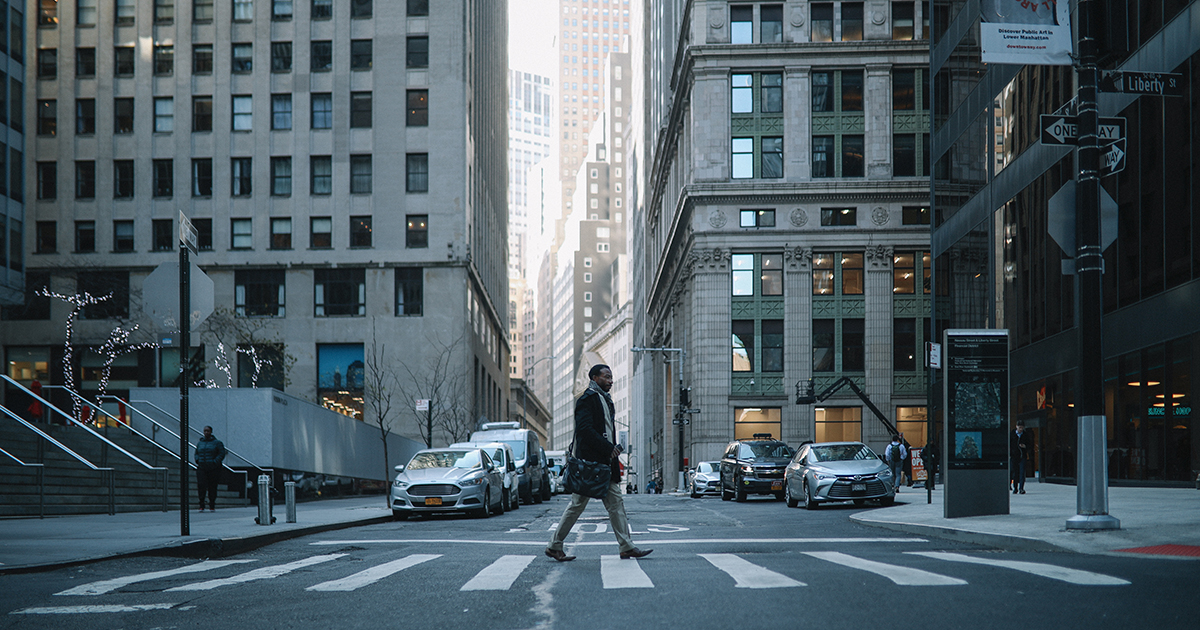 Man crossing the street in a busy city