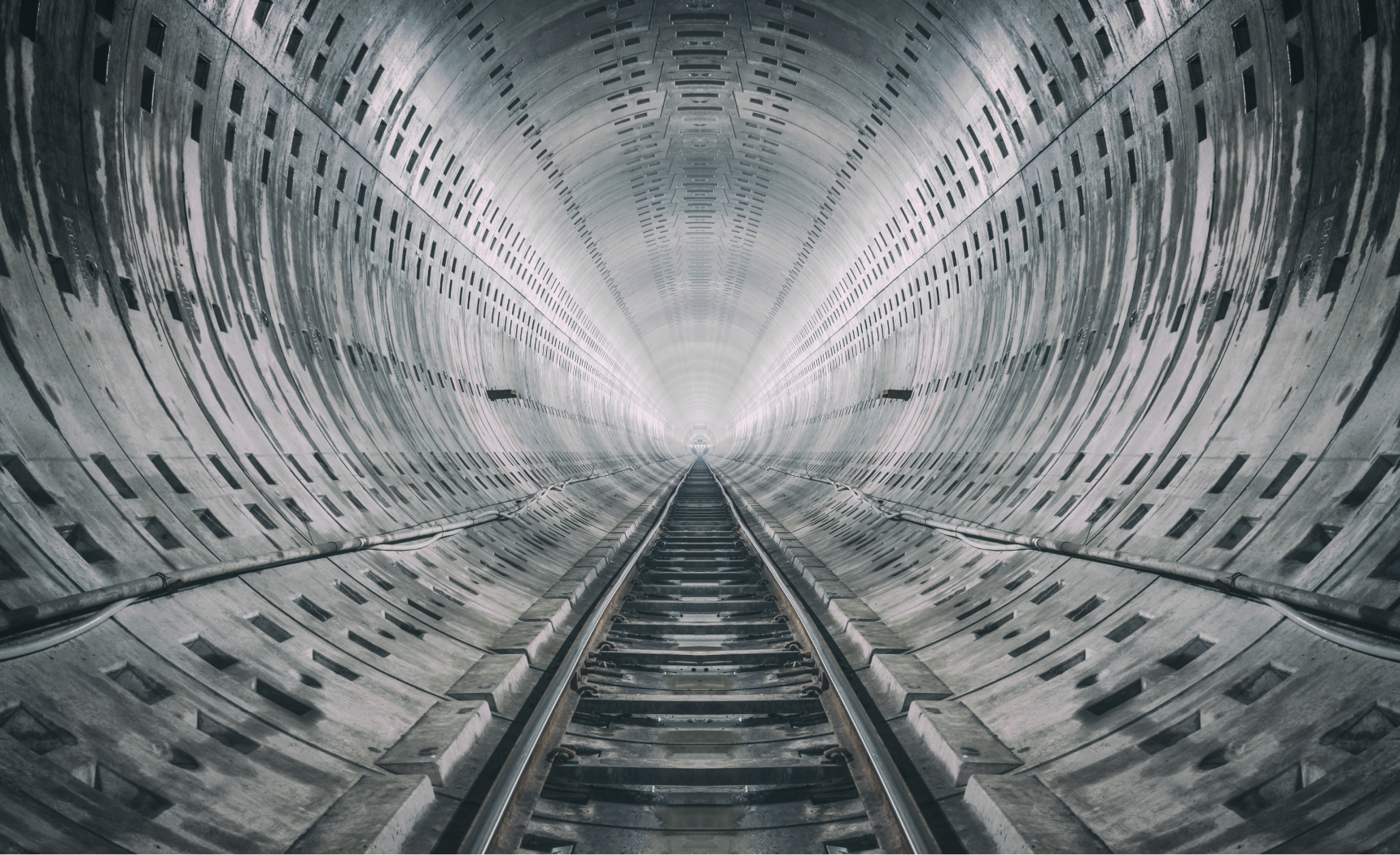 Silver and grey tunnel with train tracks